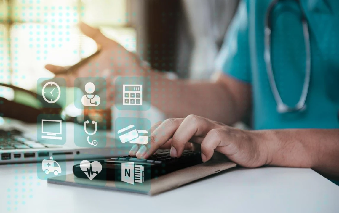 Medical Billing and Healthcare Technology – Doctor Using Laptop and Calculator Healthcare professional using laptop and calculator with digital medical billing and healthcare icons overlay